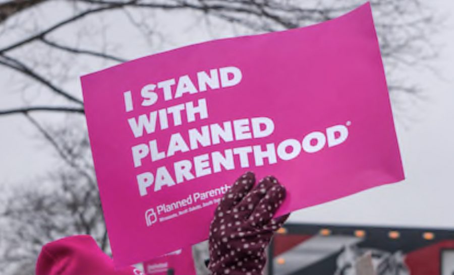 Protester holding up sign signifying their support for Planned Parenthood.