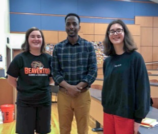 Hummer reporters Beatrice and Eleanor Kahn stand with author Abdi Nor Iftin in the MD Lecture Hall.