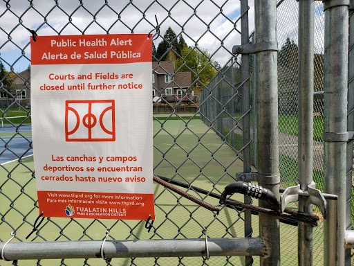 The tennis courts at Mitchell Park are locked with a notice nearby notifying community members of the closure.