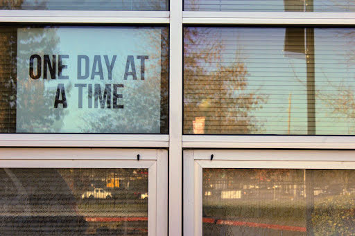 A reflective window at BHS displays a motivational poster.