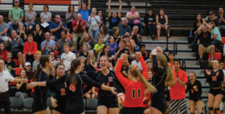 Girls’ volleyball celebrates the winning point of the second set.